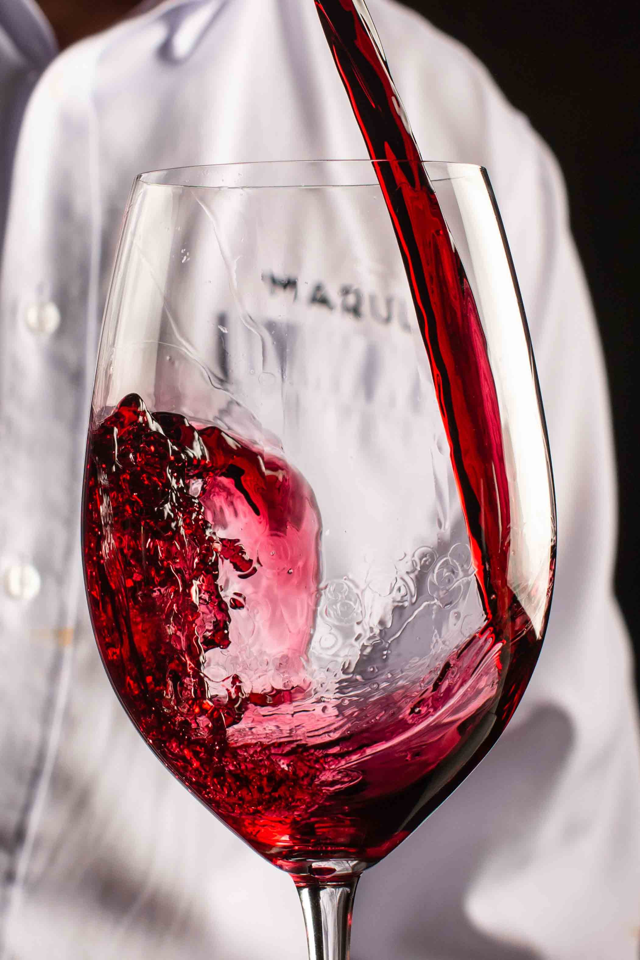 Vino tinto sirviéndose en una copa grabada con el nombre Marula